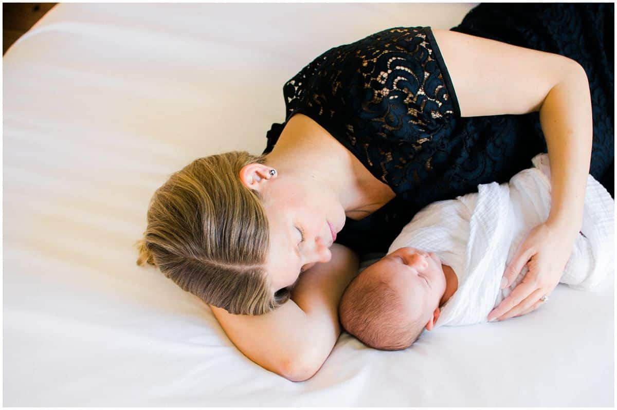 new mom with her baby laying on a bed for newborn photo