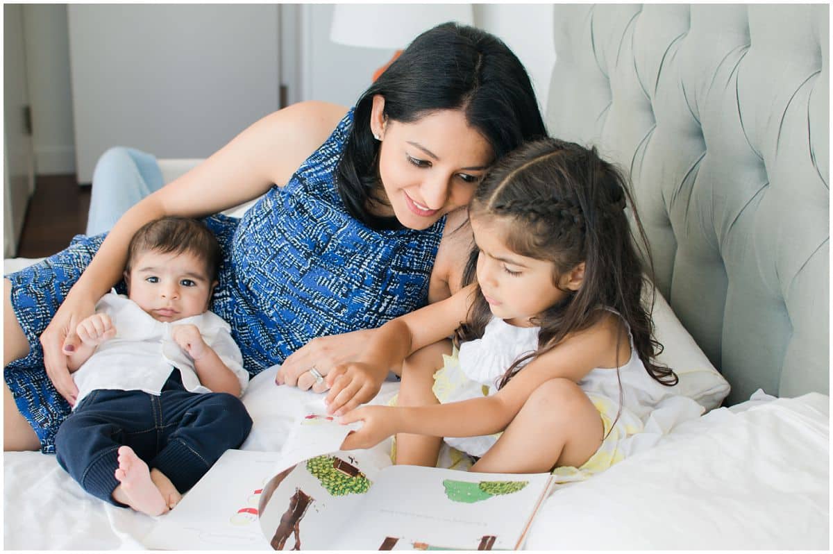 family photography in NYC at home with cute baby boys and lovely older sister reading a book