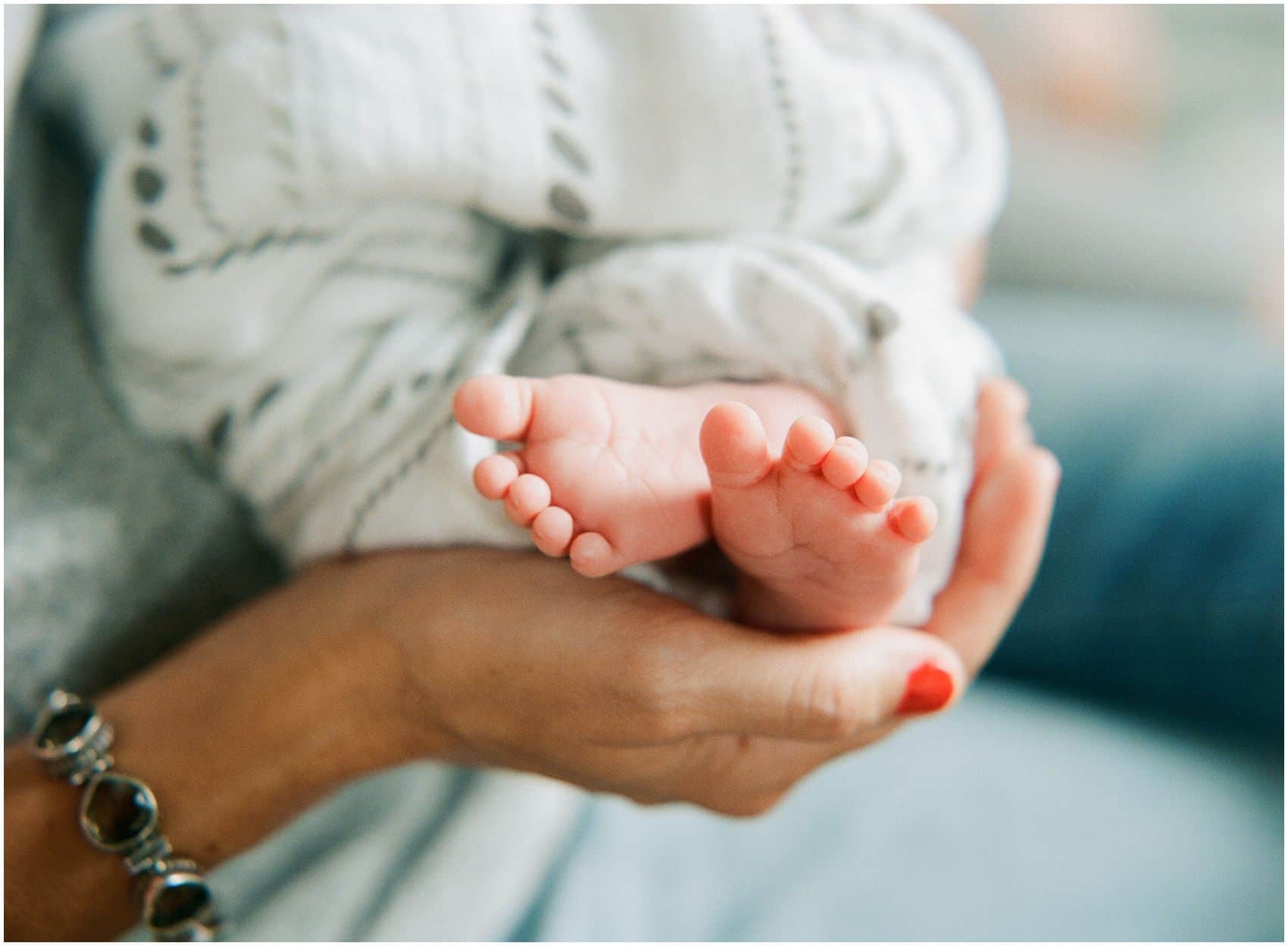 mom holding baby toes in newborn photos