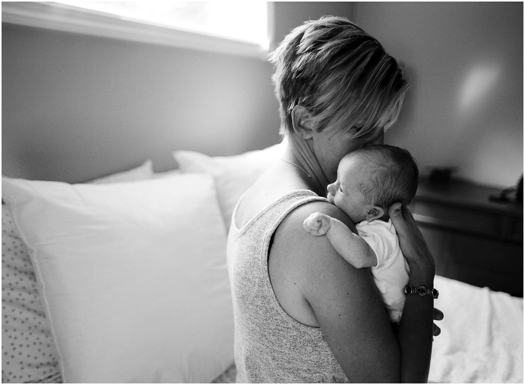 newborn photographer captures a black and white portrait of a mom holding her new baby