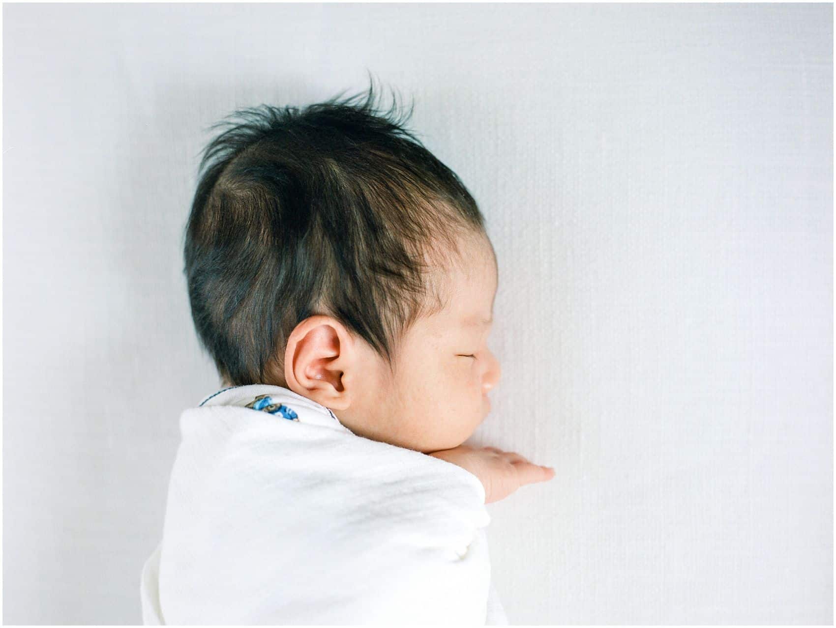 baby boy wearing white for the newborn portrait 