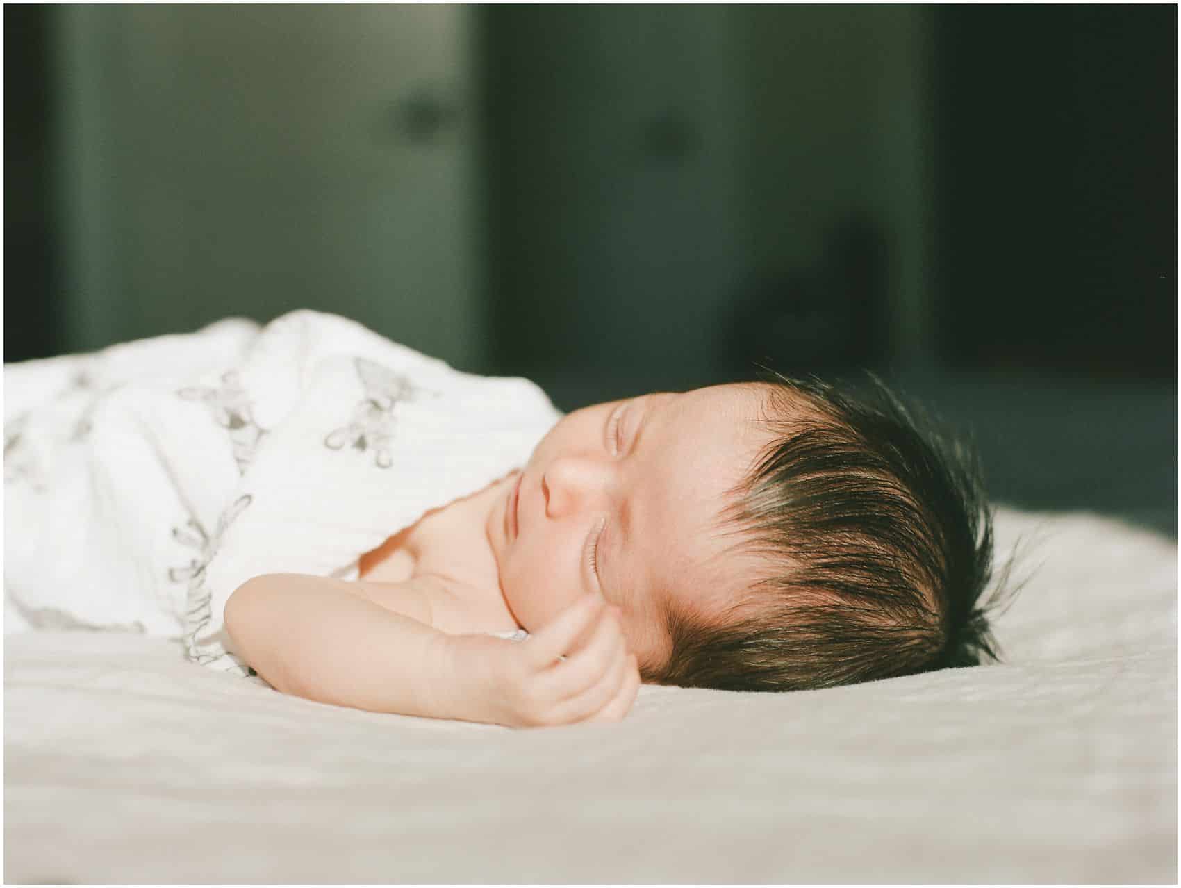 baby girl sleeping in the sunlight at her artistic newborn portraits 