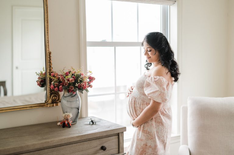 Maternity photographer NYC captures pregnant woman in floral nursery, Manhattan