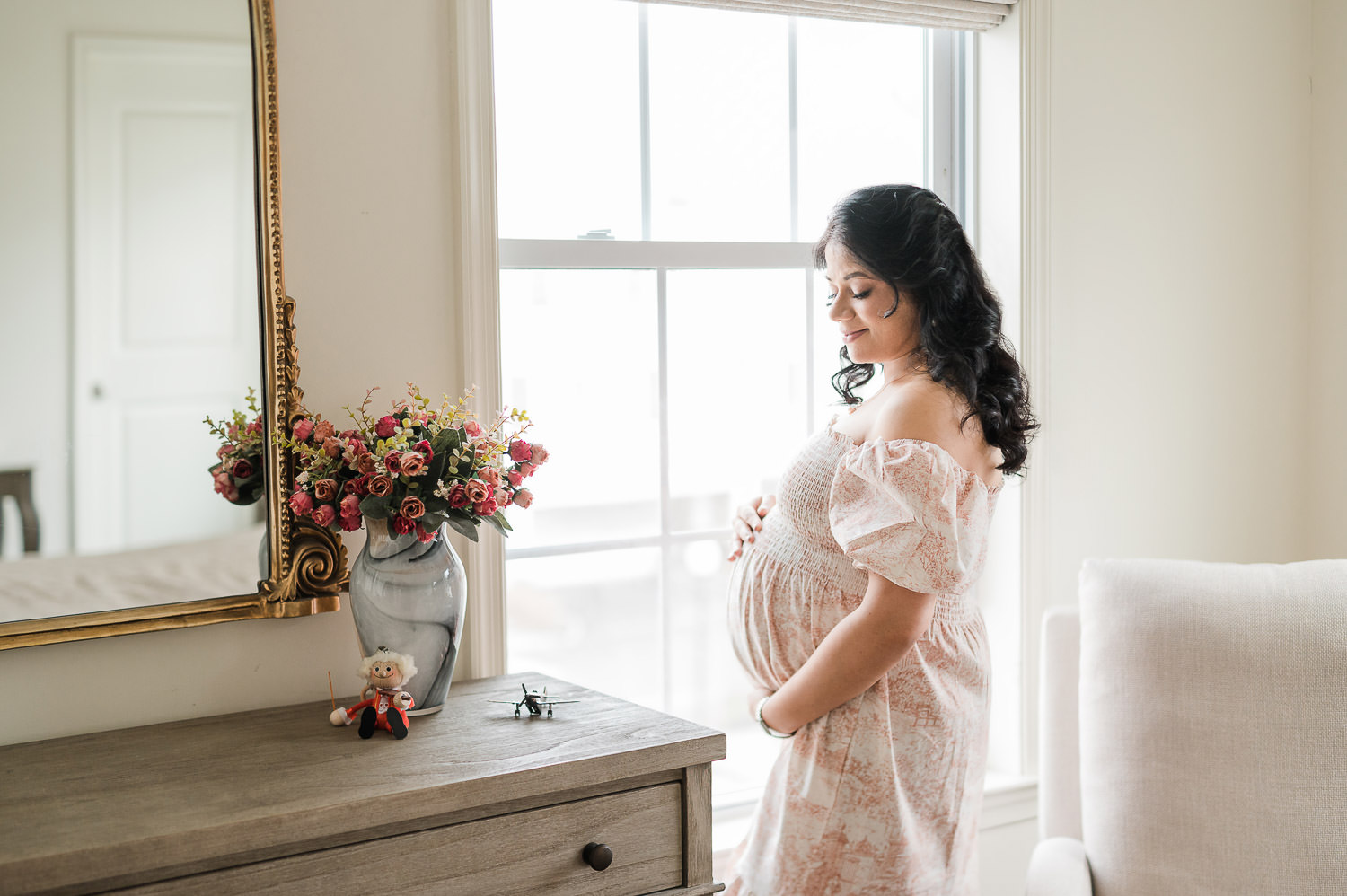 Maternity photographer NYC captures pregnant woman in floral nursery, Manhattan