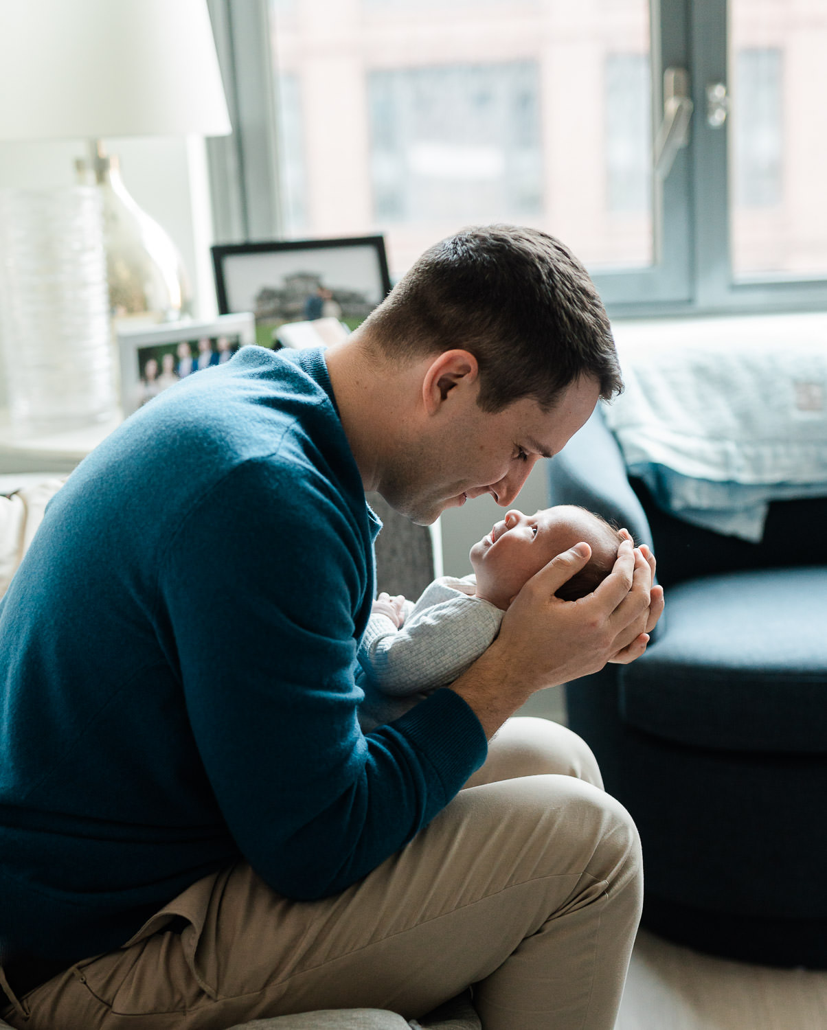 Father nose to nose with newborn baby in NYC apartment — in-home newborn photographer Manhattan