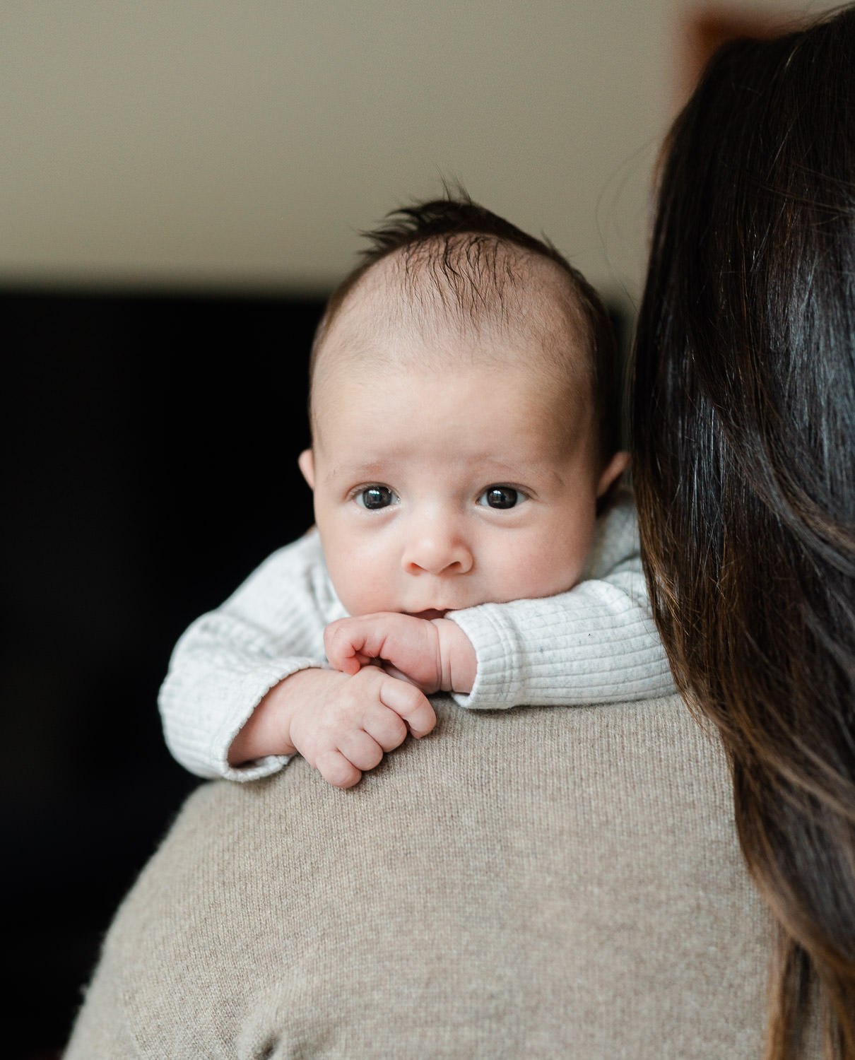 Alert newborn baby looking over mother's shoulder — lifestyle newborn photographer Park Slope Brooklyn