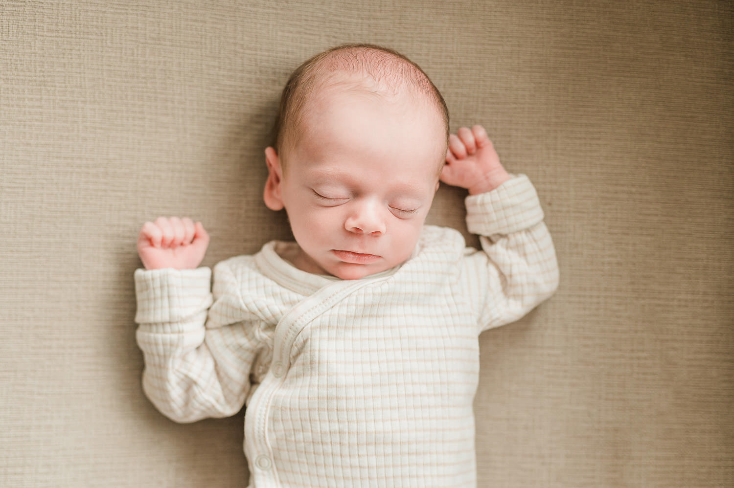 Newborn baby sleeping with arms raised — in-home newborn photographer NJ