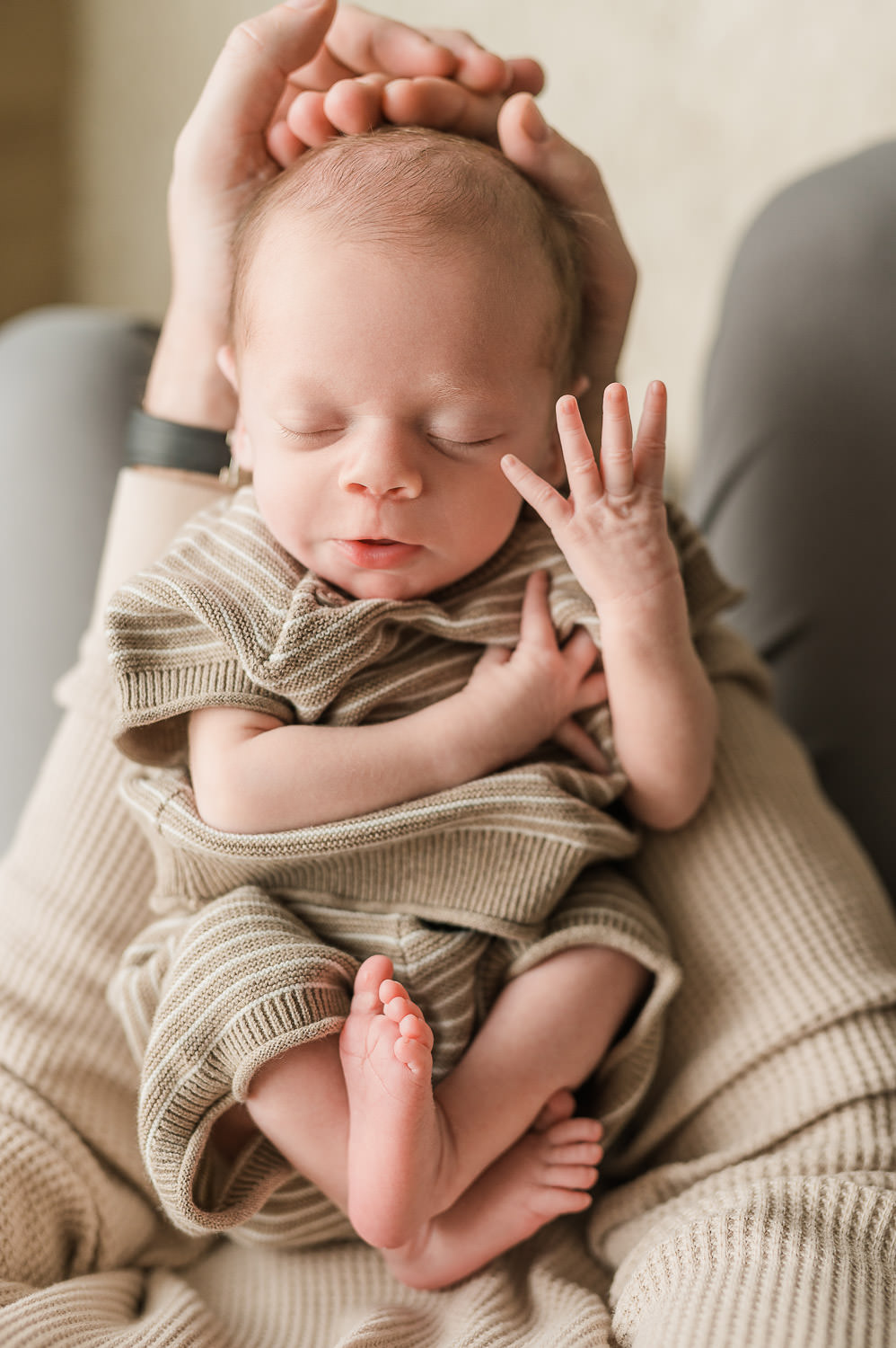 Parent holding newborn baby in arms — in-home newborn session NJ