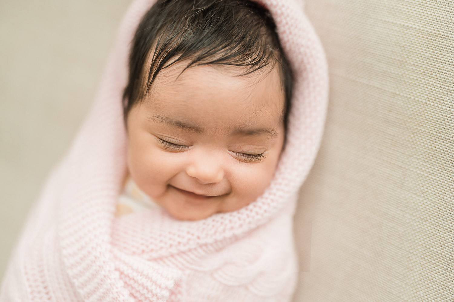 Smiling newborn baby swaddled in blanket at three weeks — in-home newborn photographer NJ