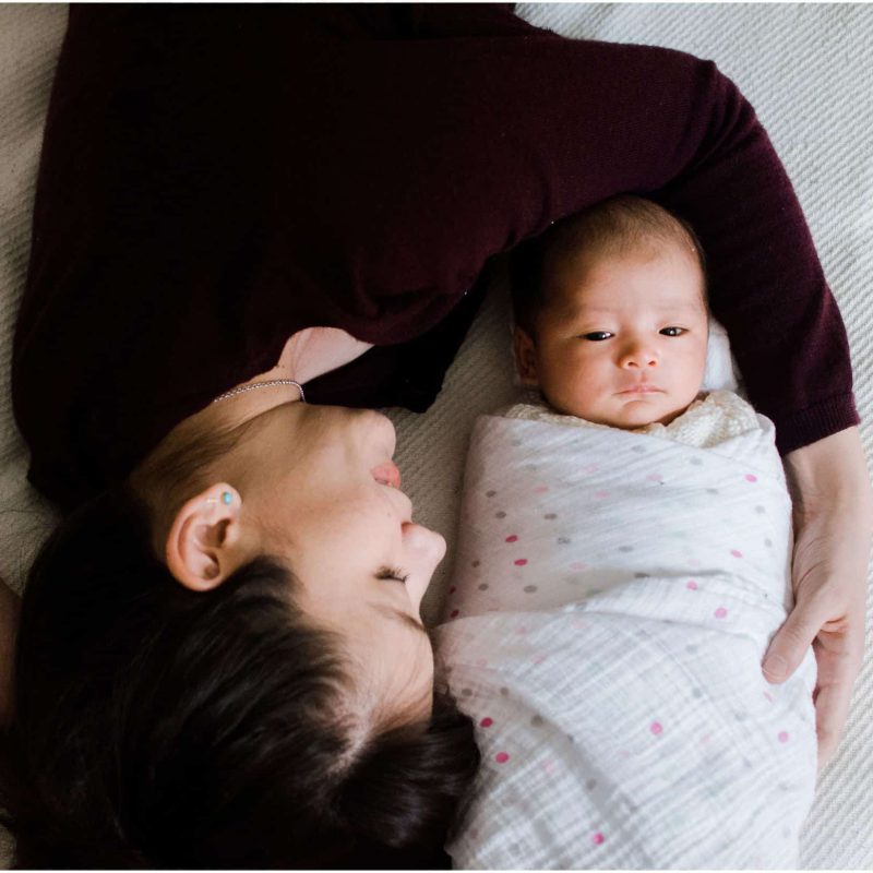 newborn photography NYC with mom cuddling around her baby