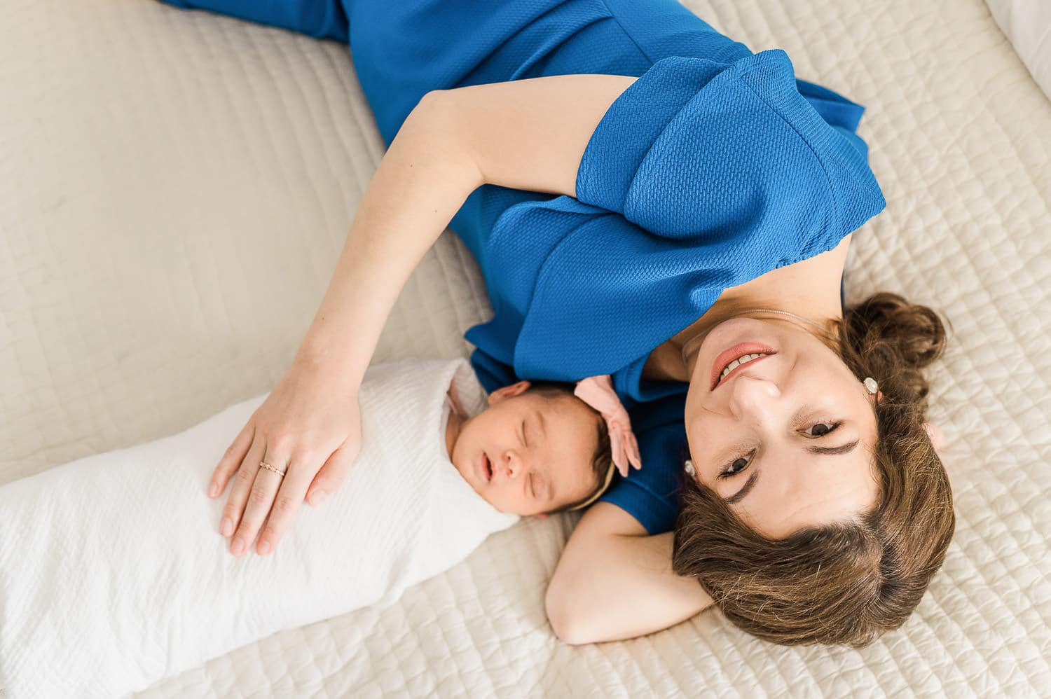 Natural light streaming through Upper East Side apartment window during newborn session illuminating mom and her baby