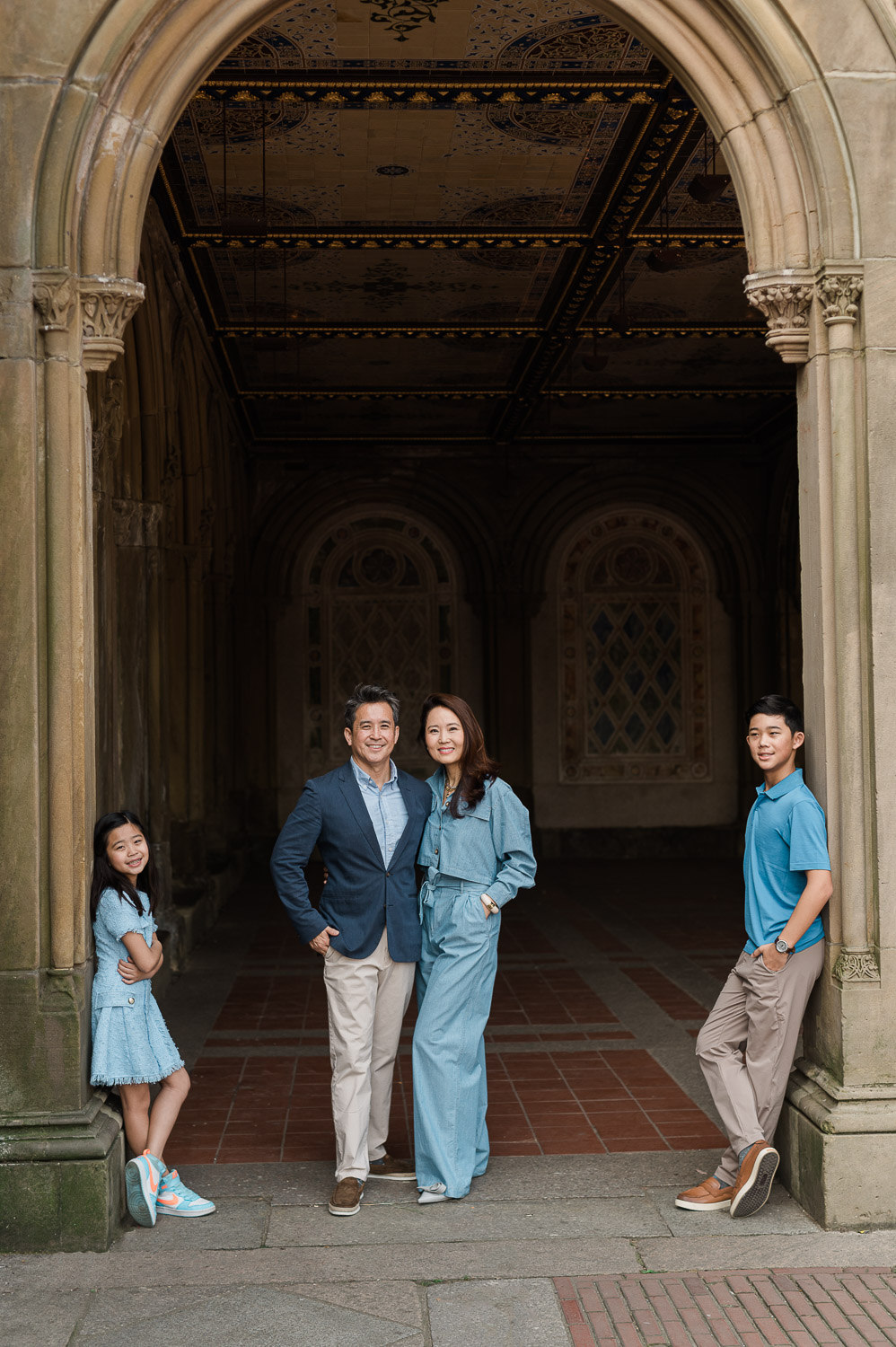 Manhattan family posing for professional photos under Bethesda Terrace arches Central Park