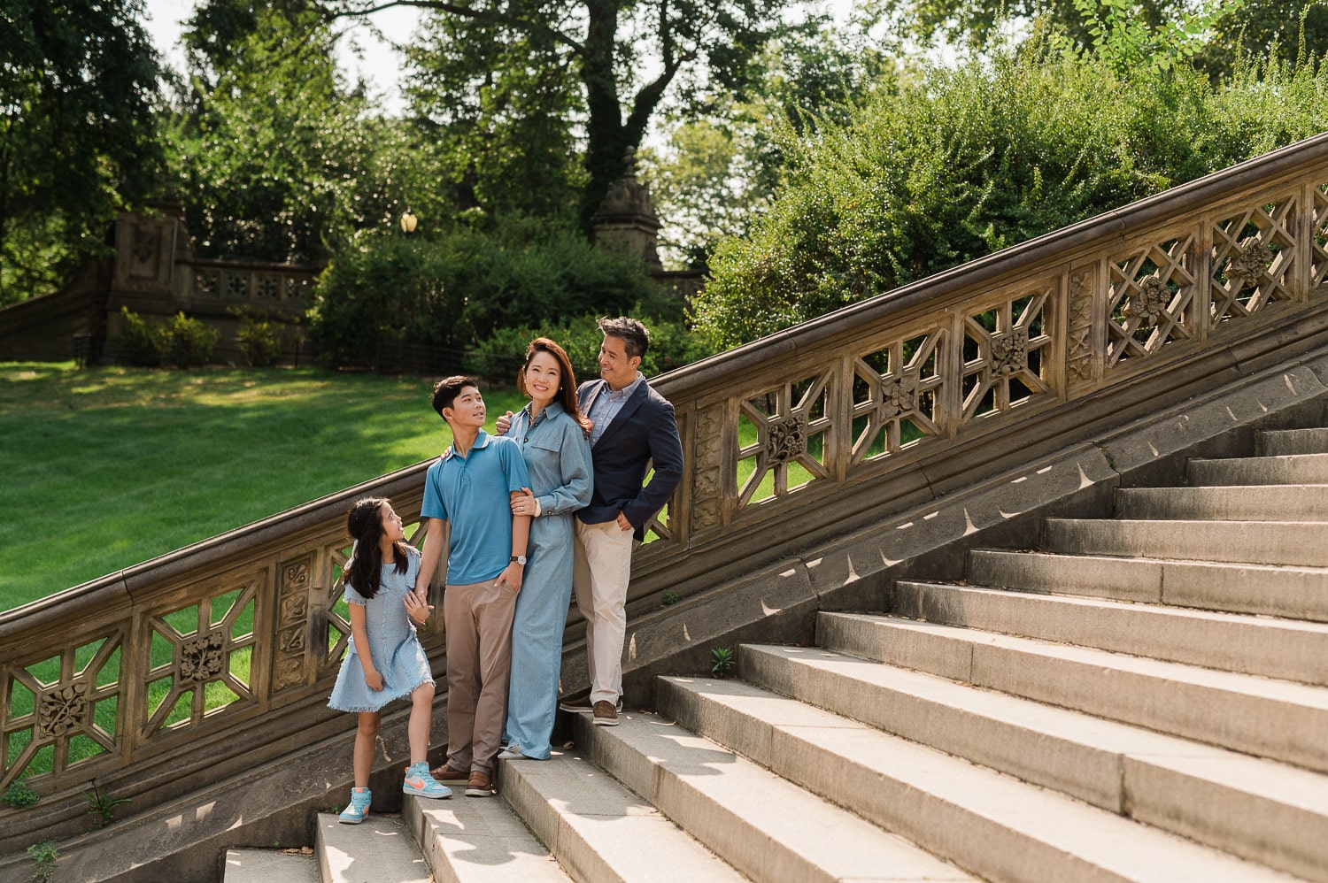Family walking together down the steps of Bethesda Terrace during early morning Central Park photo session NYC