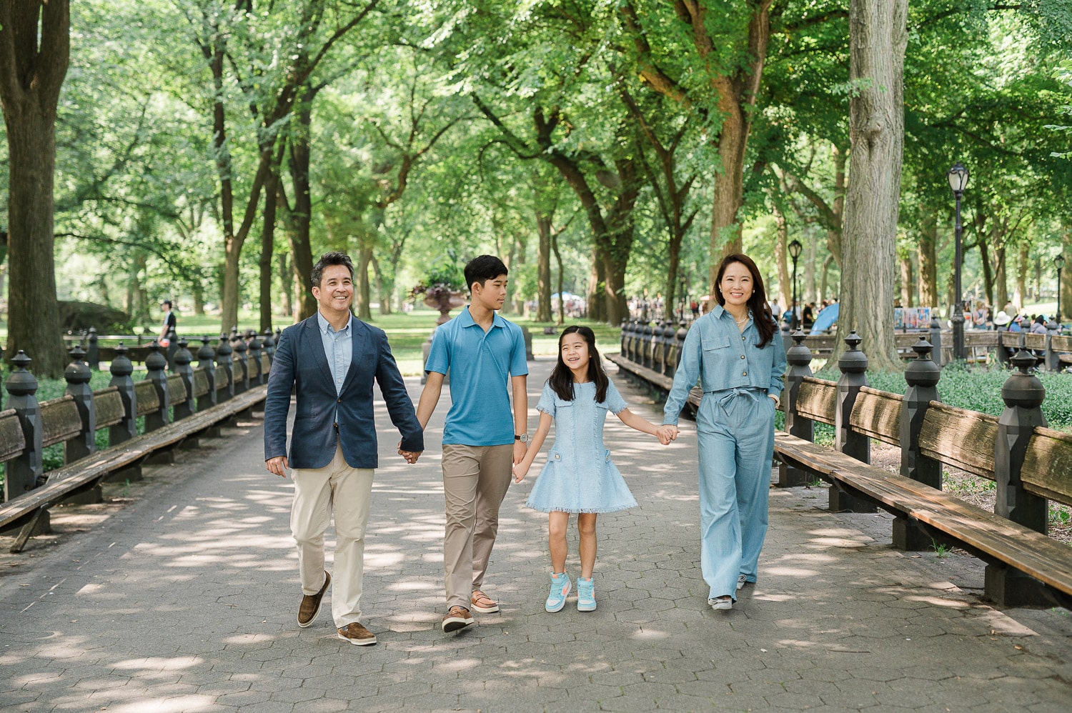 NYC family photographer capturing family walking under the trees at Central Park photo session