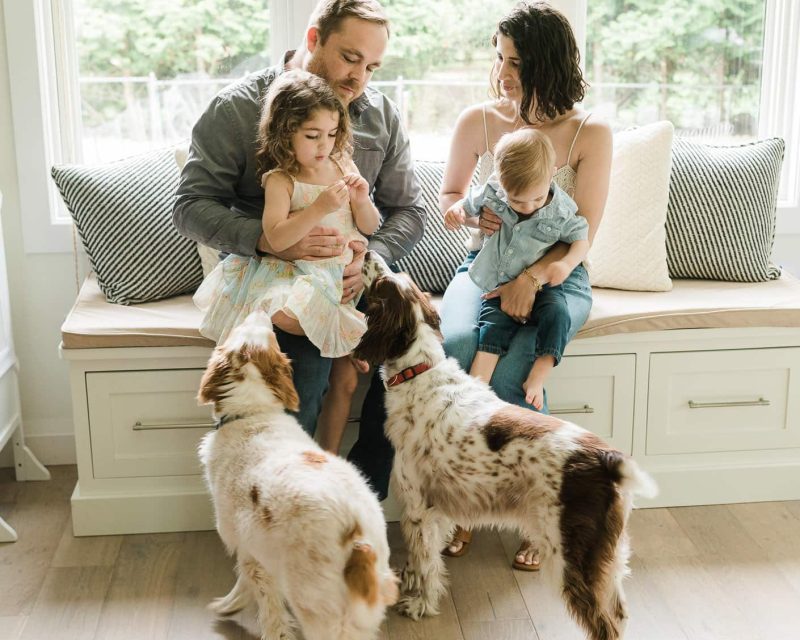 Parents with kids and dogs sharing playful moment in Summit, NJ