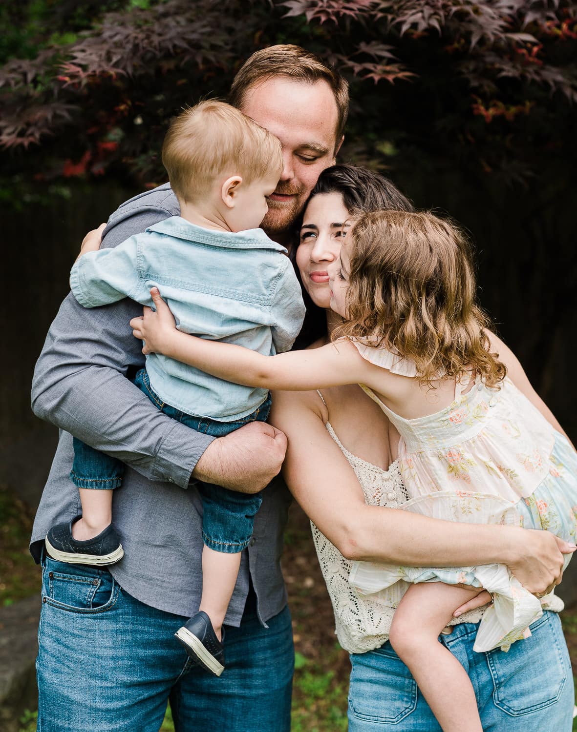 Parents hugging children in cozy home portrait, Summit, NJ
