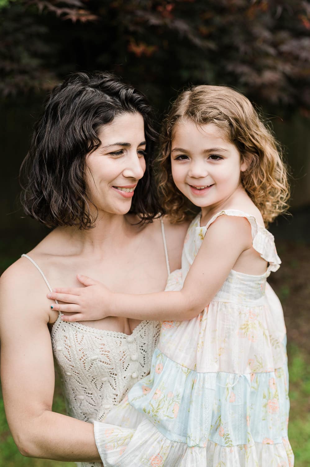 mom hugging small daughter in cozy backyard portrait, Summit, NJ