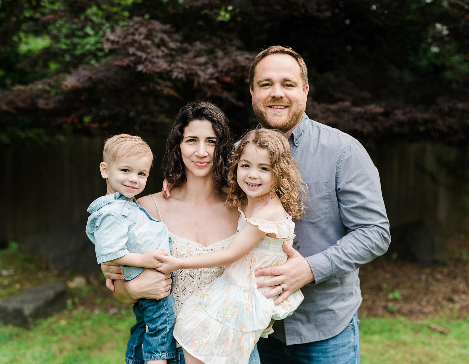 Candid family moment with laughing kids in backyard during lifestyle photography session in Summit NJ