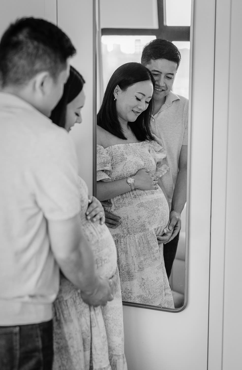Intimate maternity photo with couple looking into the mirror baby’s nursery room in Park Slope, Brooklyn.