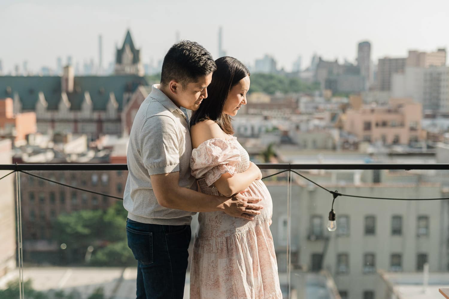 Elegant maternity portraits on rooftop overlooking Manhattan skyline