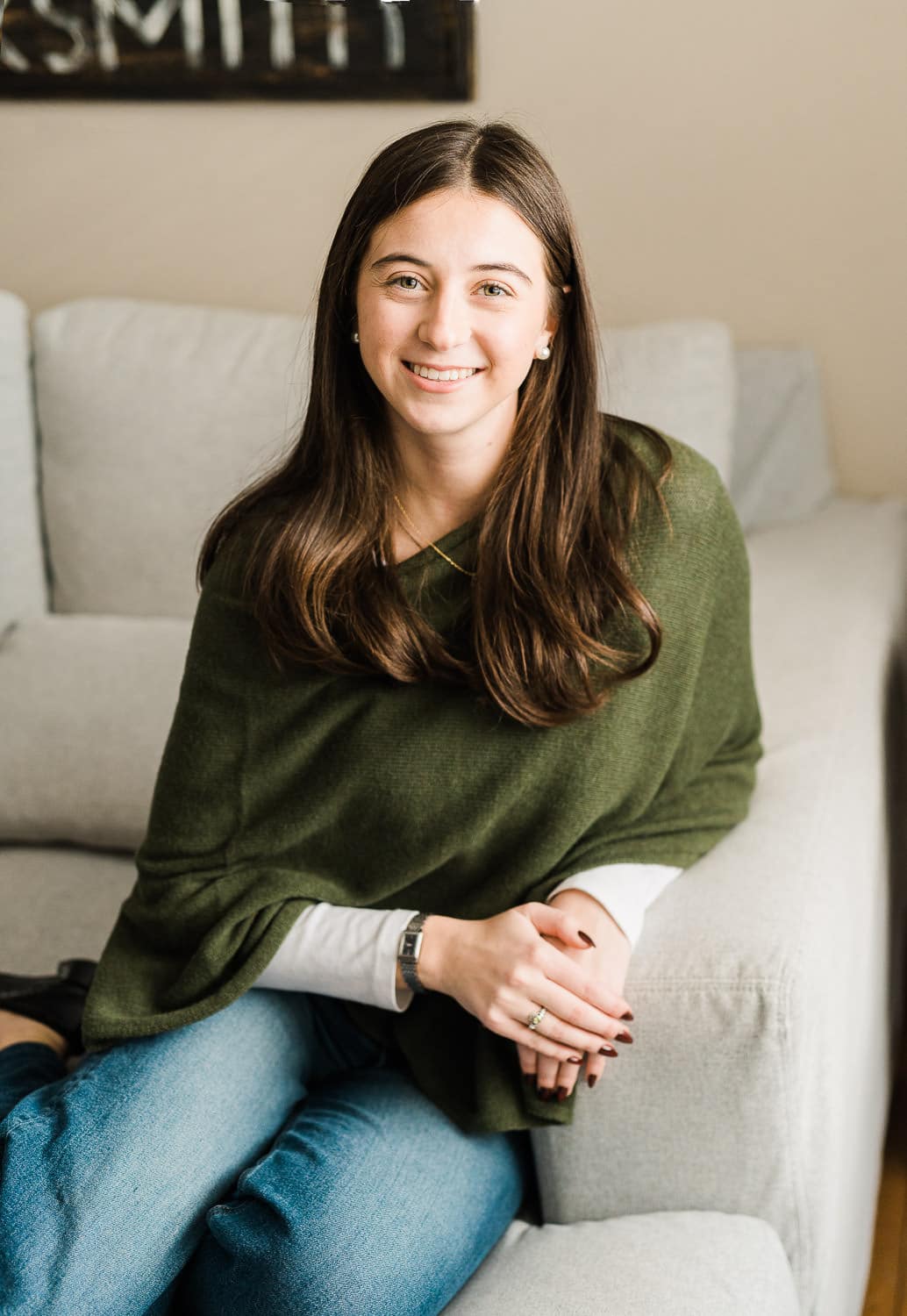 Young woman seated on sofa during senior portrait session — Miriam Dubinsky Photography