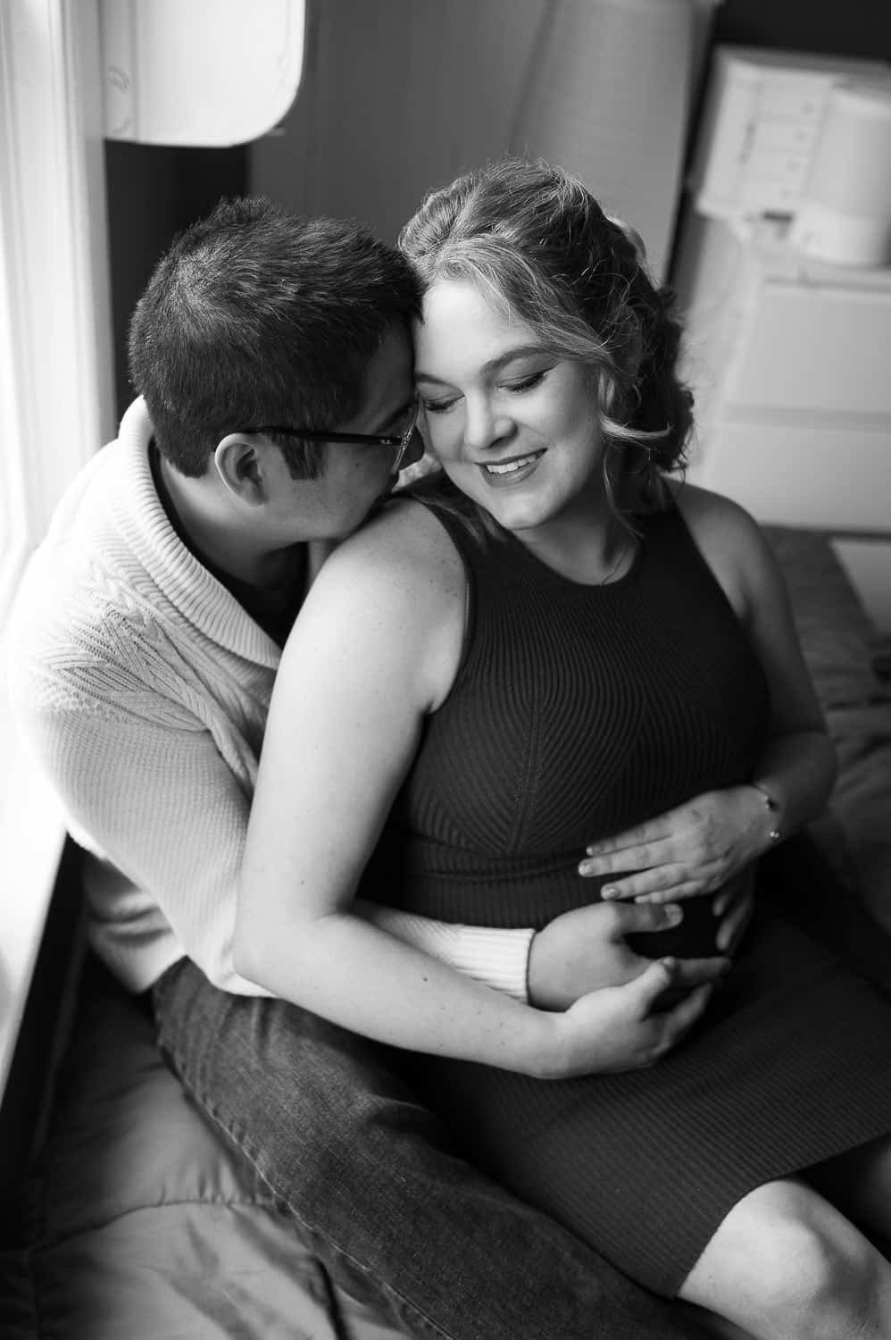 Indoor black and white maternity photography in Morristown NJ with soft window light and couple close together