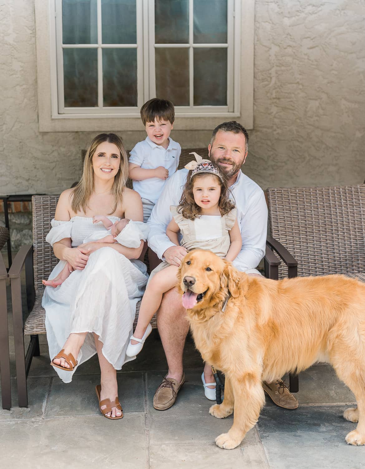 Family of five in white outfits with golden retriever — in-home newborn photographer Short Hills NJ