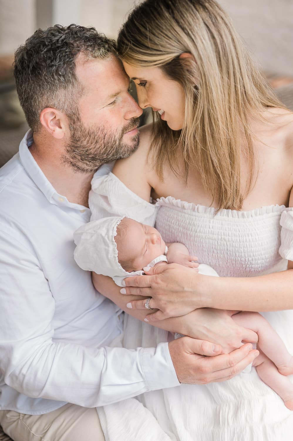 Mom and dad forehead to forehead with newborn baby girl — intimate in-home newborn session Short Hills NJ