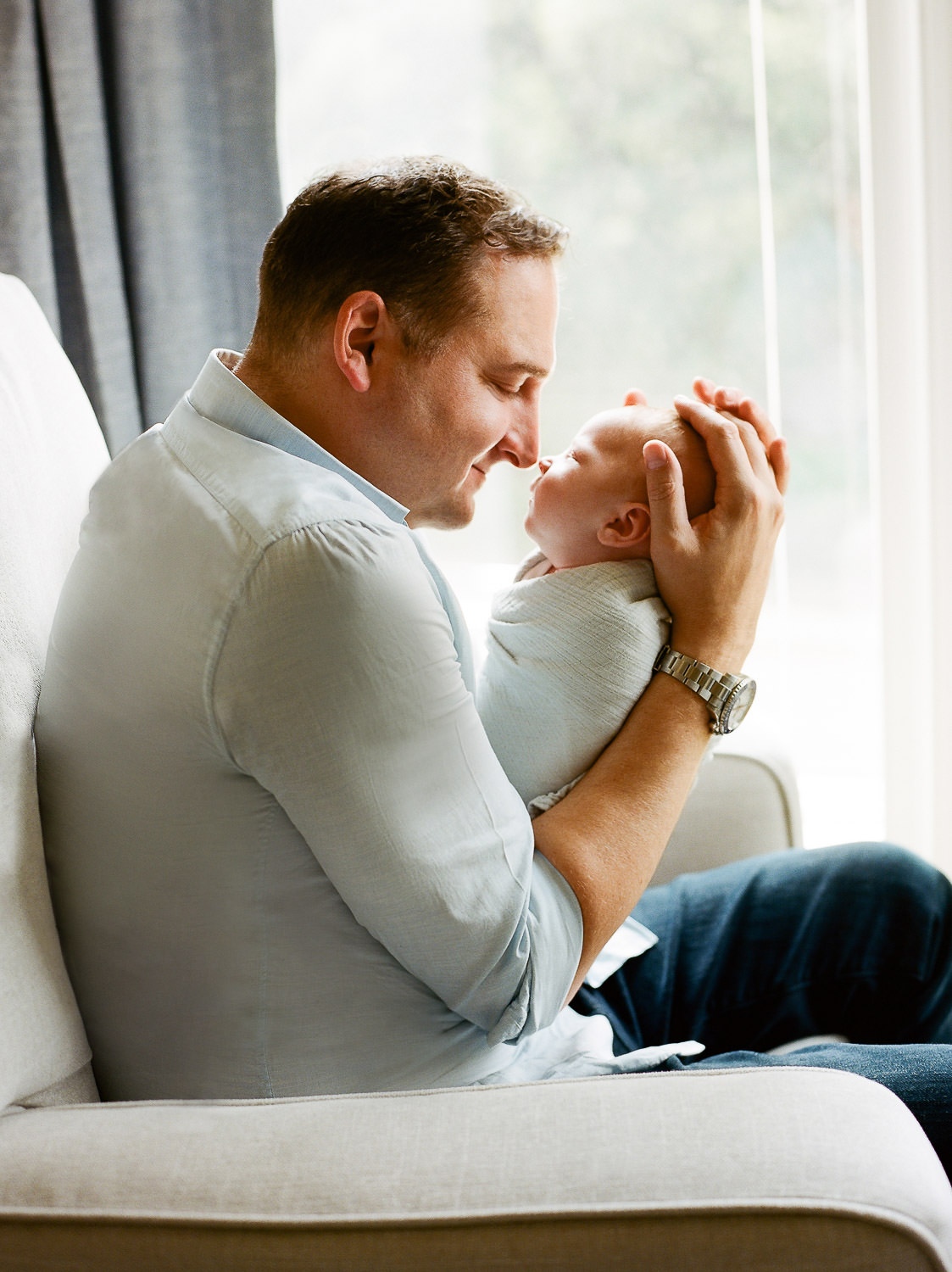 dad holding newborn baby during in-home lifestyle session NYC and NJ" — add NYC here