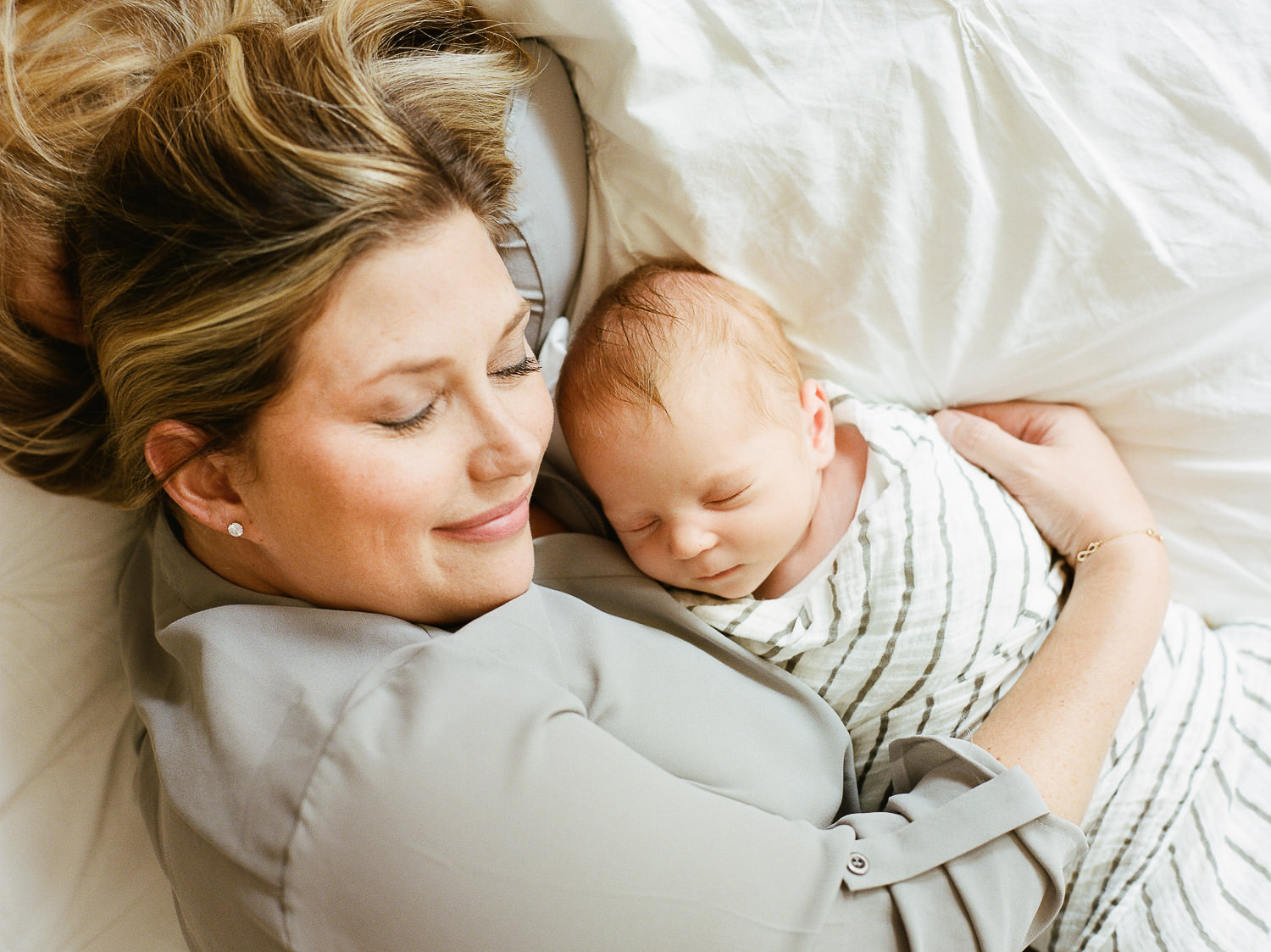 how to choose a newborn photographer in NJ — mom holding newborn baby boy at home