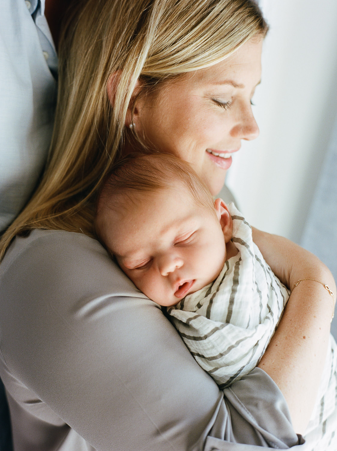 Mom holding her sleeping baby over her shoulder — how to choose newborn photographer in NJ