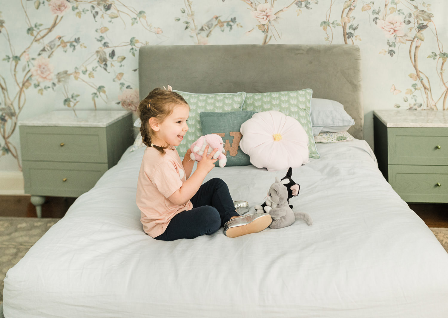 little girl playing in her bedroom on a bed with a stuffy and photographed by Miriam Dubinsky Photography