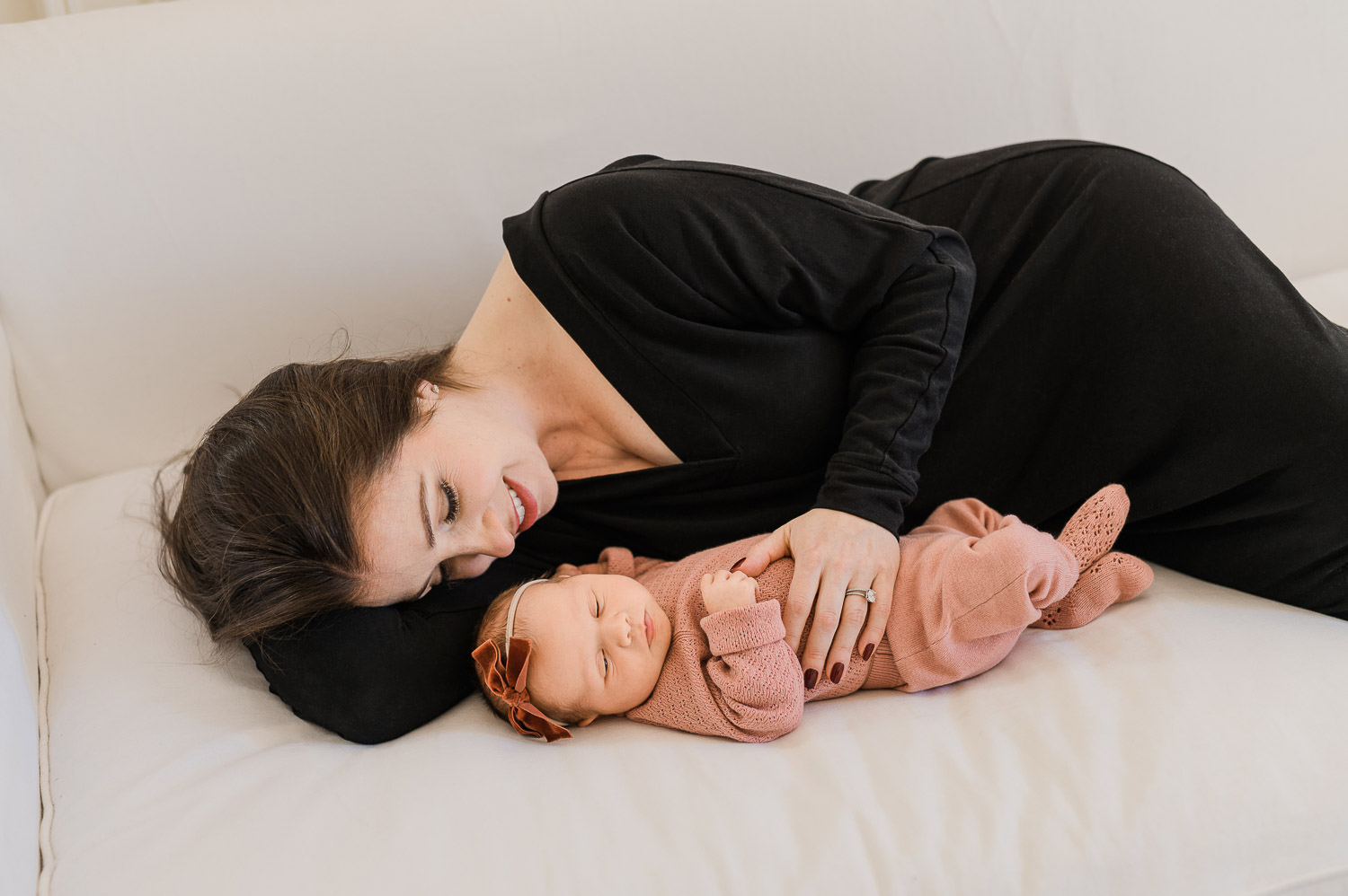 mother is cuddling wiht her new baby girl during NYC newborn photography session by Miriam Dubinsky